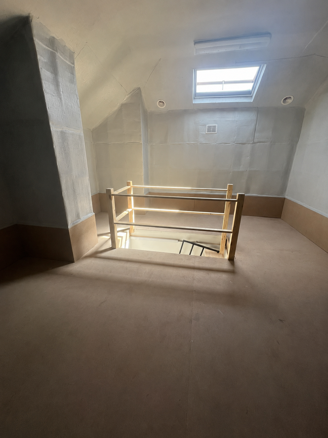 Clean, sealed dust-free attic storage room with fresh flooring, skylight and timber balustrade in a Sydney home